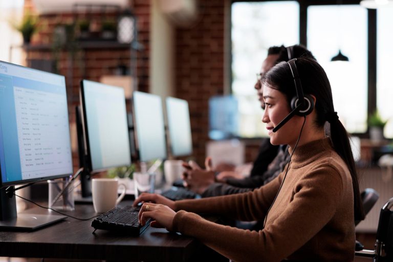 Corporate team collaborating productively in a pleasant bright office with laptops, experiencing seamless operations free from technology downtime.